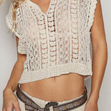 Woman wearing a beige crochet top and skirt with a belt against a plain background