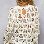 Woman wearing a white crochet top with a gray background