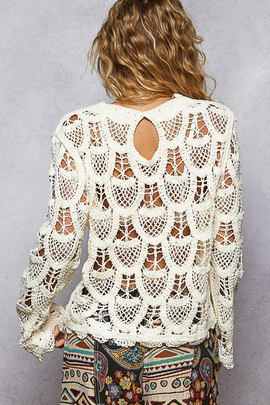 Woman wearing a white crochet top with a gray background