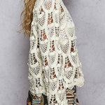 Woman wearing a white crochet top against a gray background