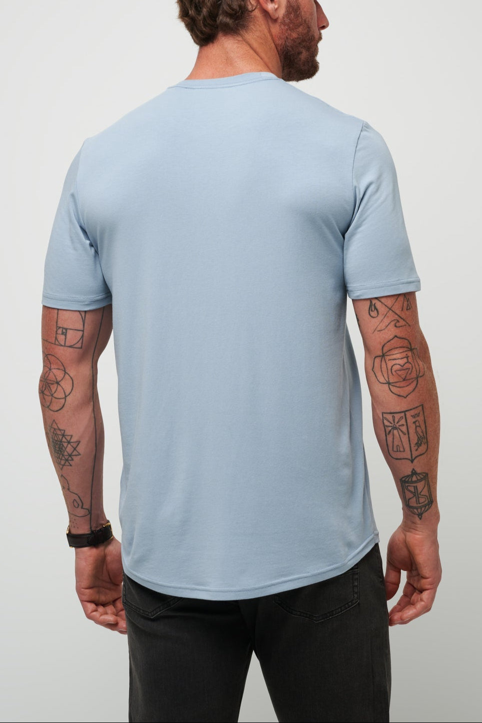 Man wearing a light blue t-shirt against a plain background