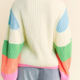 Person wearing a colorful striped sweater on a beige background