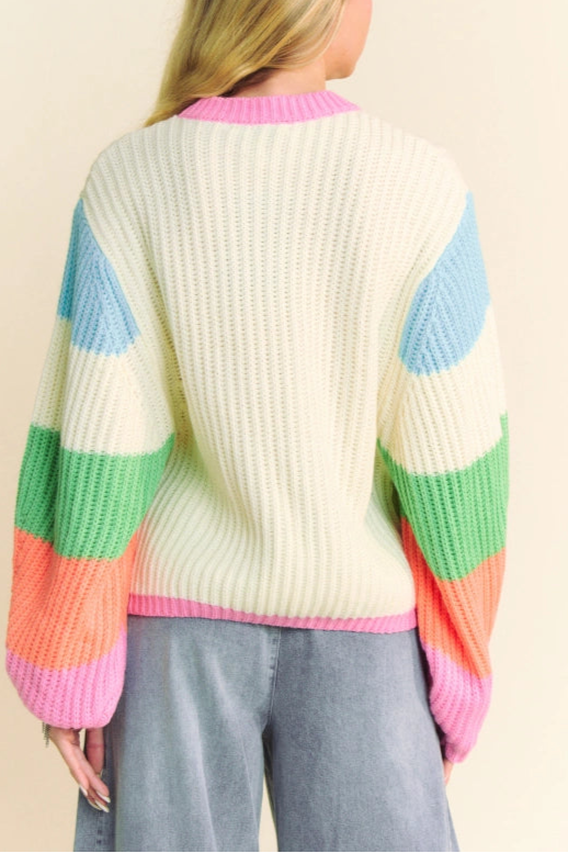 Person wearing a colorful striped sweater on a beige background