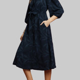 Woman wearing a navy dress against a red background