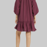 Woman wearing a plum dress with 'UMEE Exclusive' branding on a white background