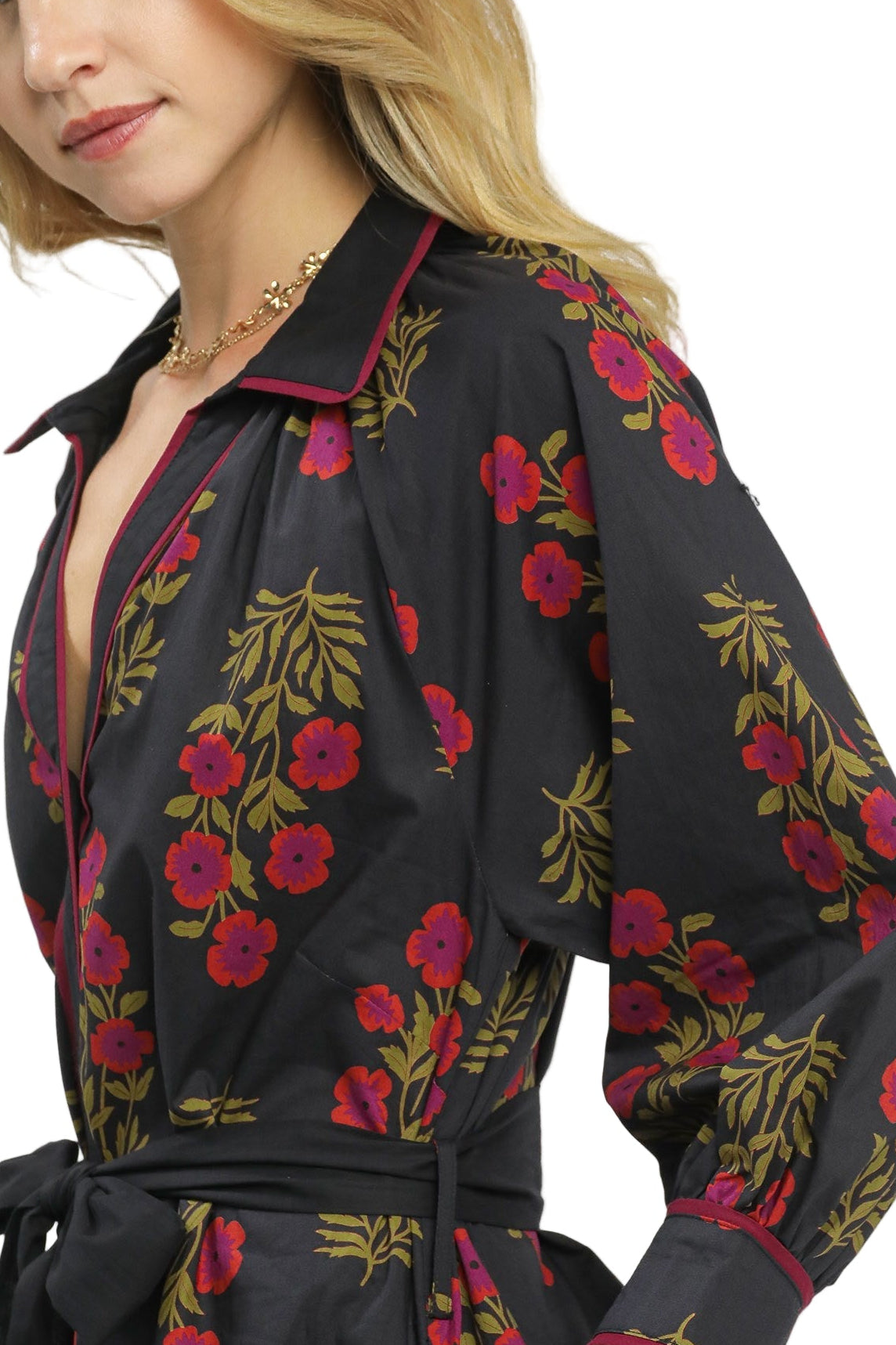 Woman wearing a black floral dress with a plain background