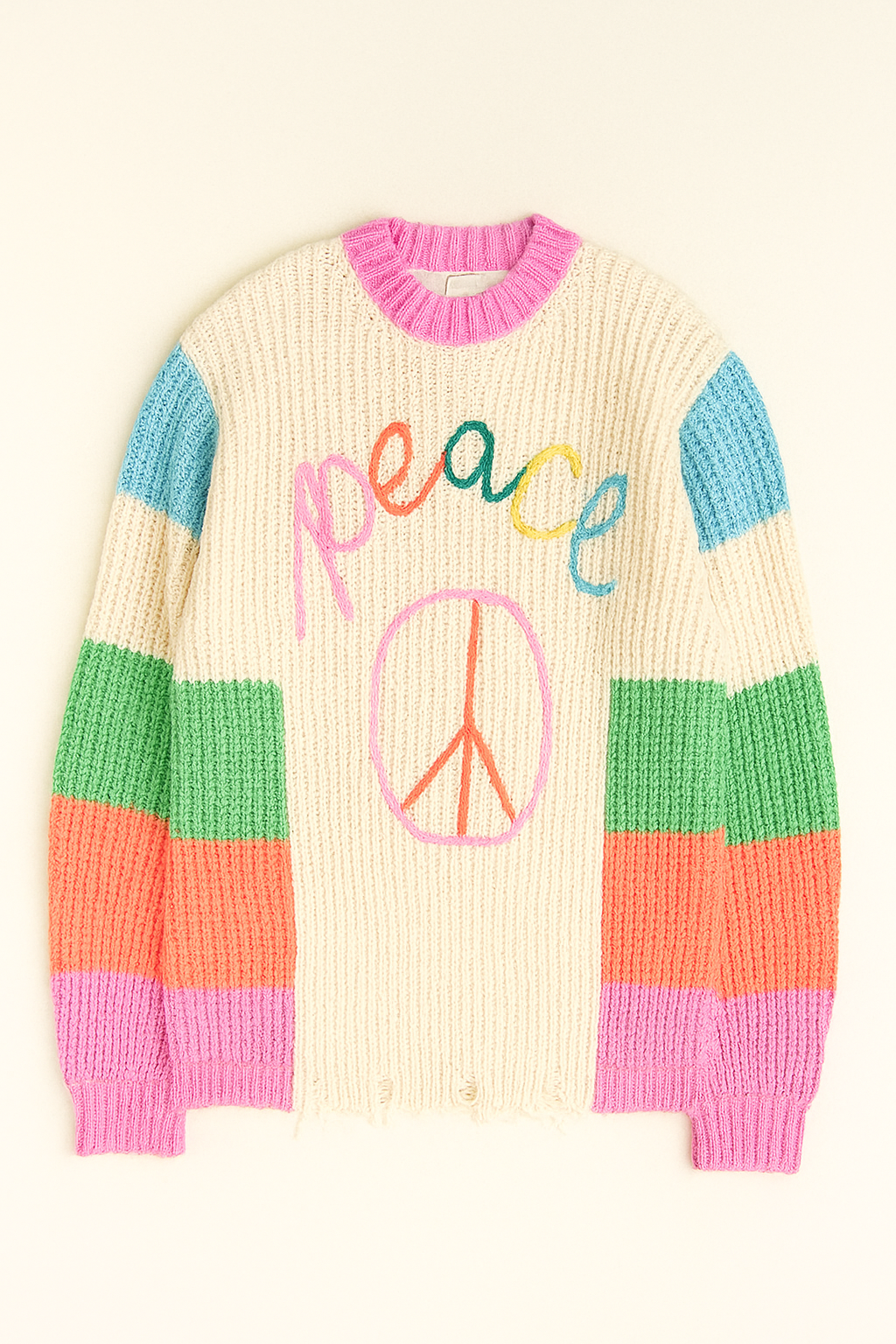 Colorful sweater with 'peace' and peace sign design on a beige background