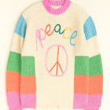 Colorful sweater with 'peace' and peace sign design on a beige background