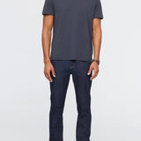 Man wearing a dark gray t-shirt and dark blue jeans on a white background