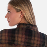Person wearing a plaid shirt with 'Jettly' branding on the collar against a white background
