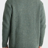 Green sweater worn by a person on a white background