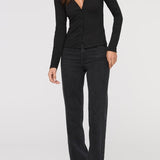Woman wearing a black long-sleeve top and black pants on a white background