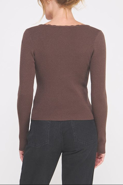 Woman wearing a brown long-sleeve top on a white background