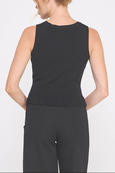 Woman wearing a black sleeveless top and black pants on a white background