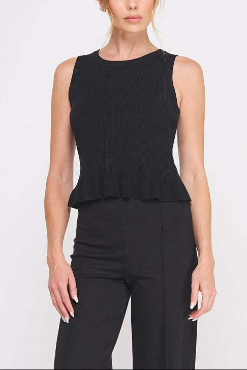 Woman wearing a black sleeveless top with a peplum waist on a white background