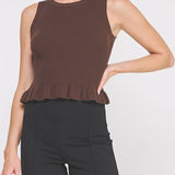Woman wearing a brown sleeveless top and black pants on a white background