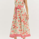 Woman wearing a floral dress with red stripes on a white background