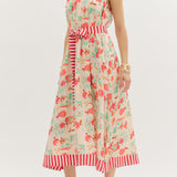 Woman wearing a floral dress with red stripes on a white background