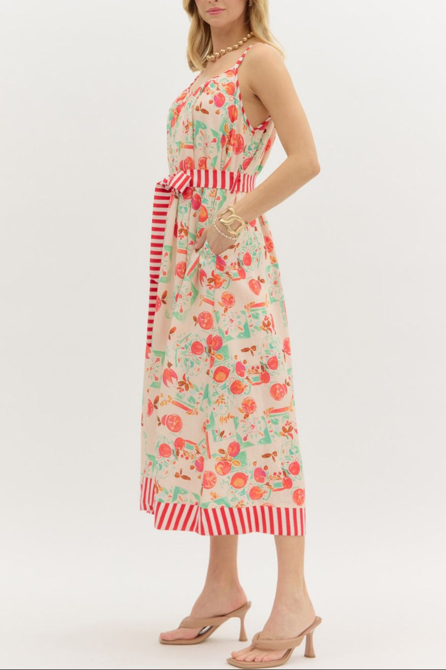 Woman wearing a floral dress with red and white striped details on a white background