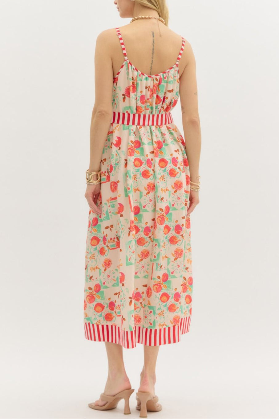 Woman wearing a floral dress with red accents on a white background