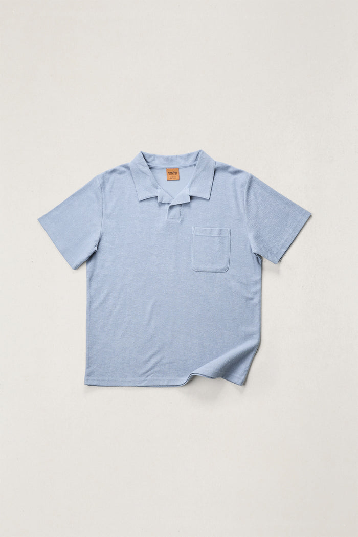 Light blue polo shirt on a light gray background