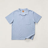Light blue polo shirt on a light gray background