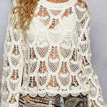 Woman wearing a white lace top with colorful pants against a gray background