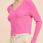 Woman wearing a bright pink sweater against a beige background