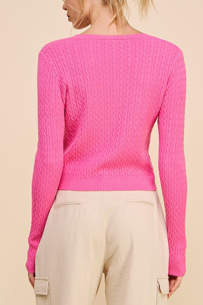 Person wearing a pink sweater on a beige background