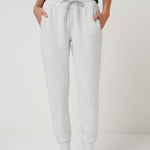 Person wearing gray sweatpants on a plain background