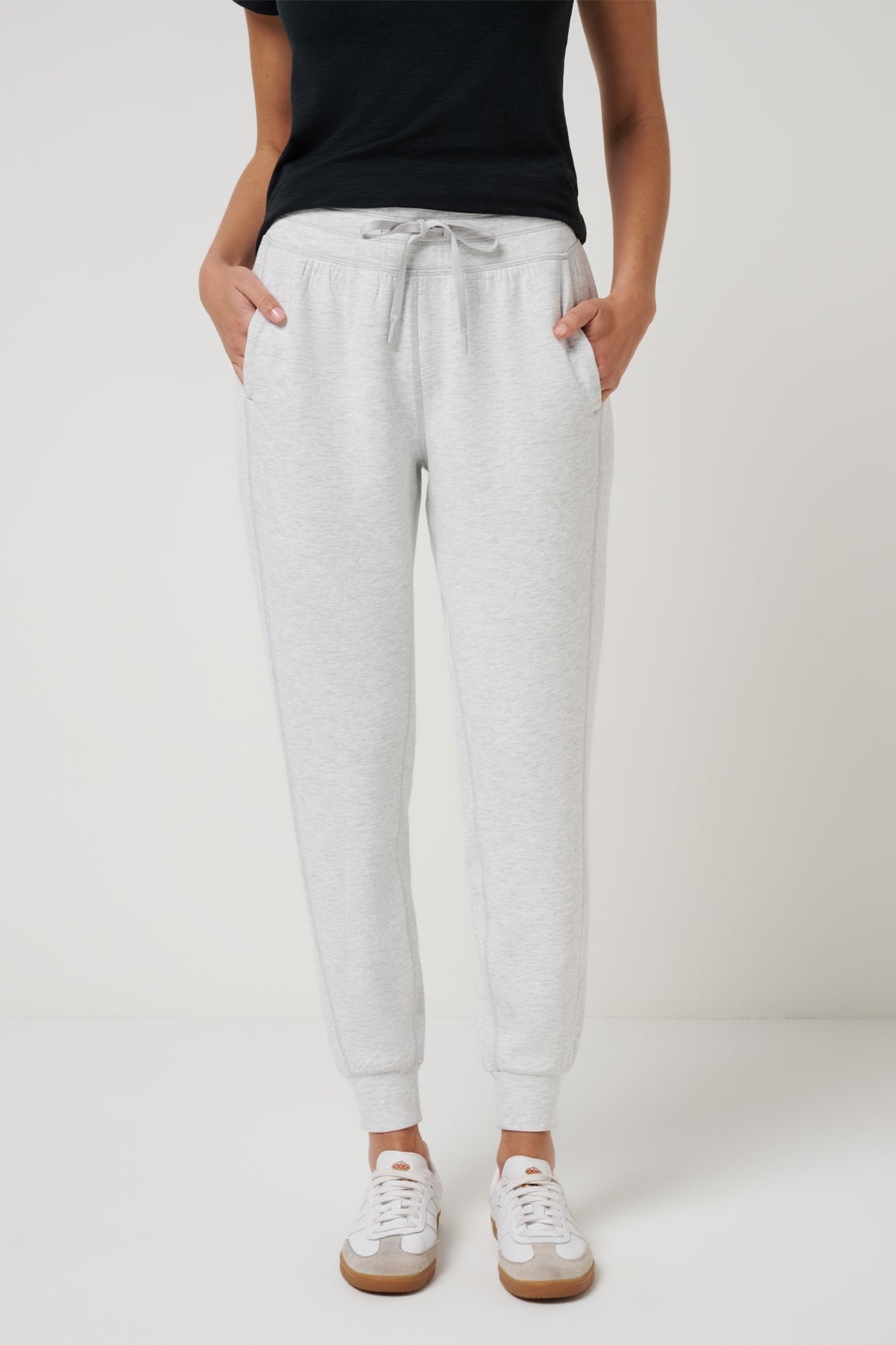 Person wearing gray sweatpants on a plain background