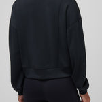 Person wearing a black jacket and pants on a plain background