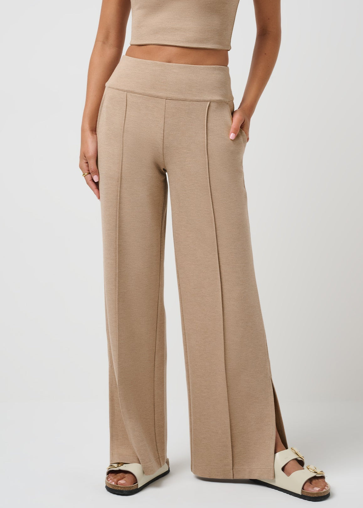 Beige high-waisted pants worn by a person on a white background