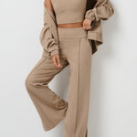 Woman wearing a beige outfit with a matching jacket against a white background