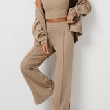 Woman wearing a beige outfit with a matching jacket against a white background