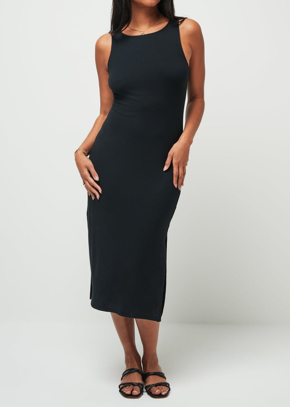 Woman wearing a black sleeveless dress against a white background