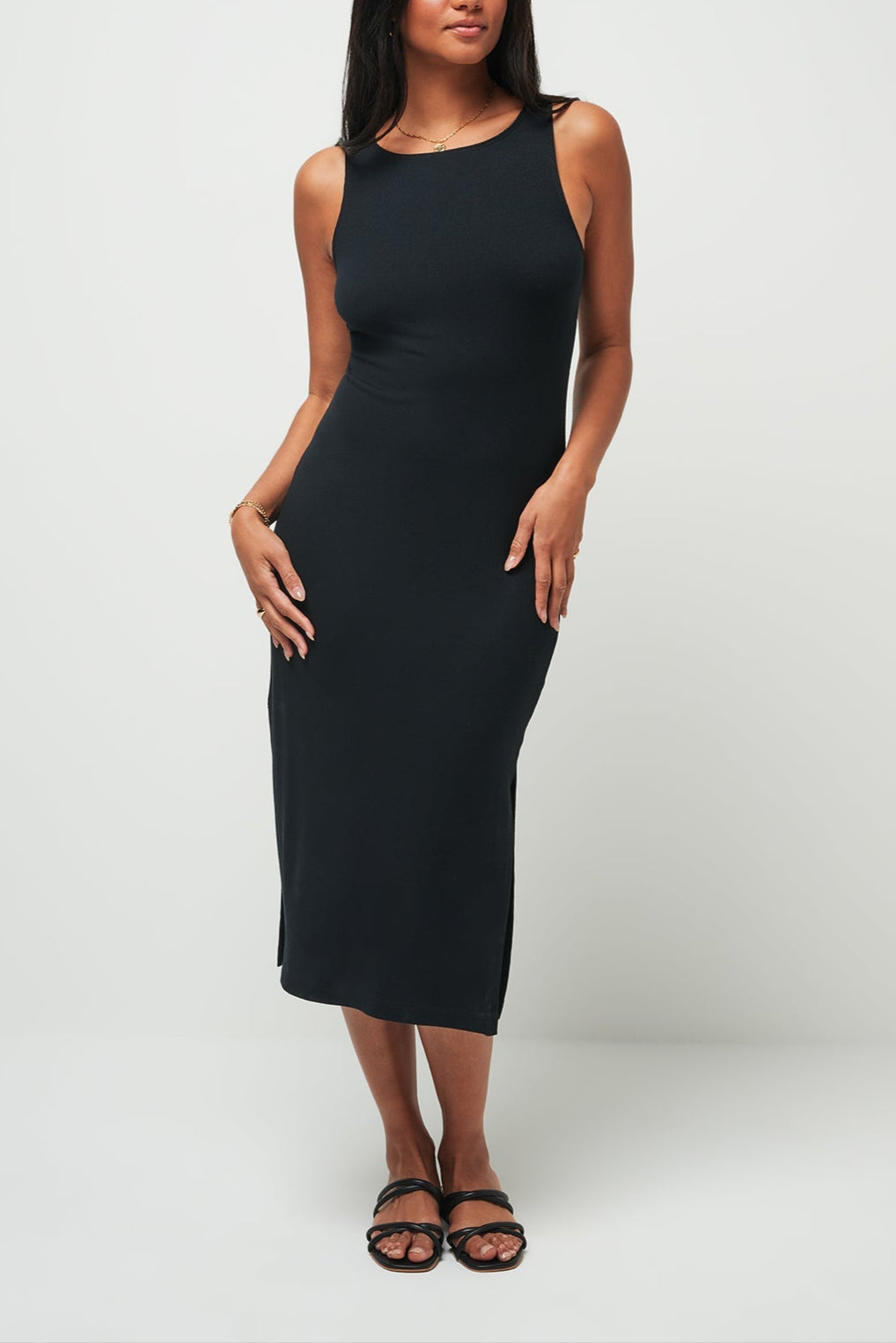 Woman wearing a black sleeveless dress against a white background