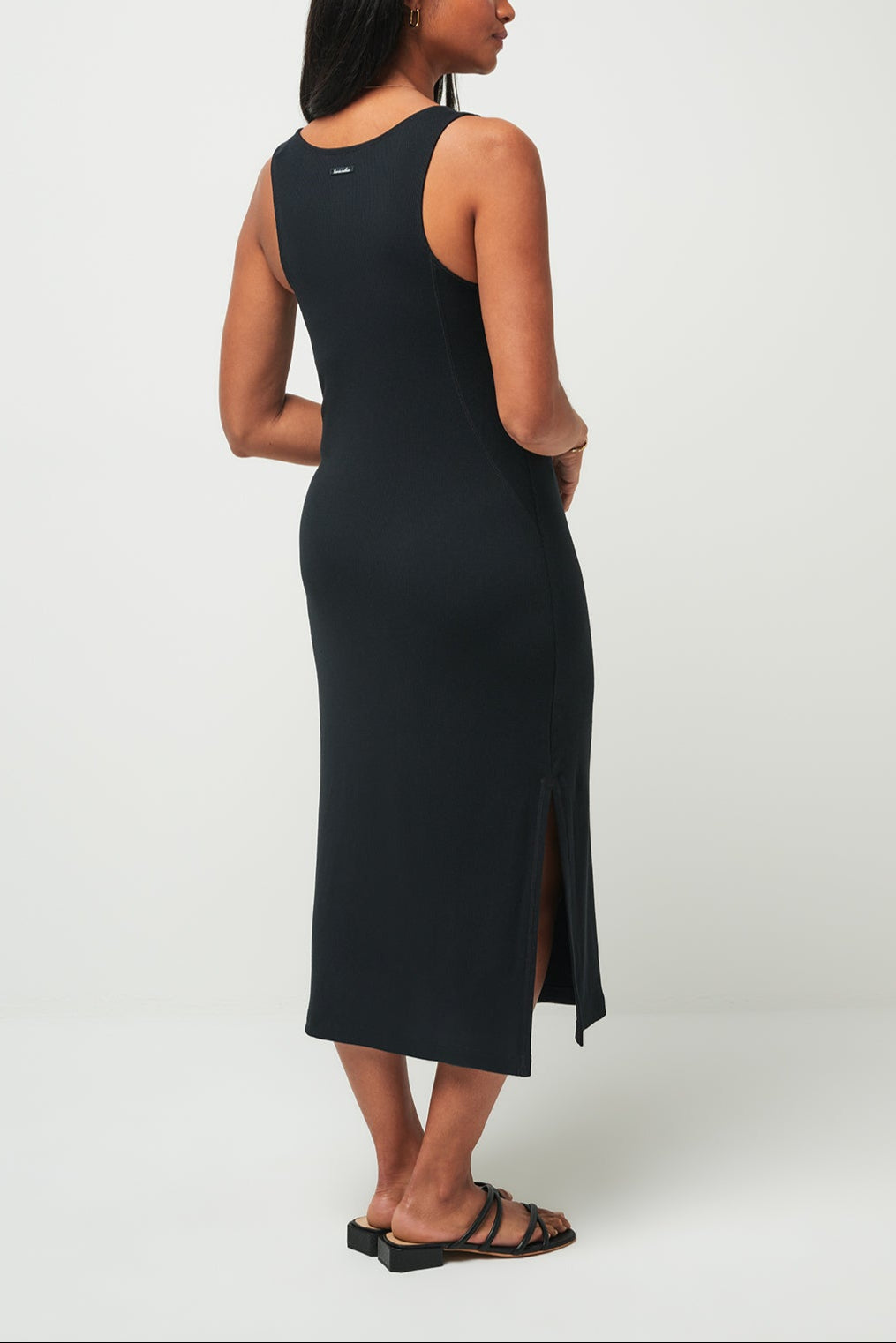 Woman wearing a black sleeveless dress on a white background