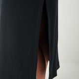 Black dress with a slit on a plain background