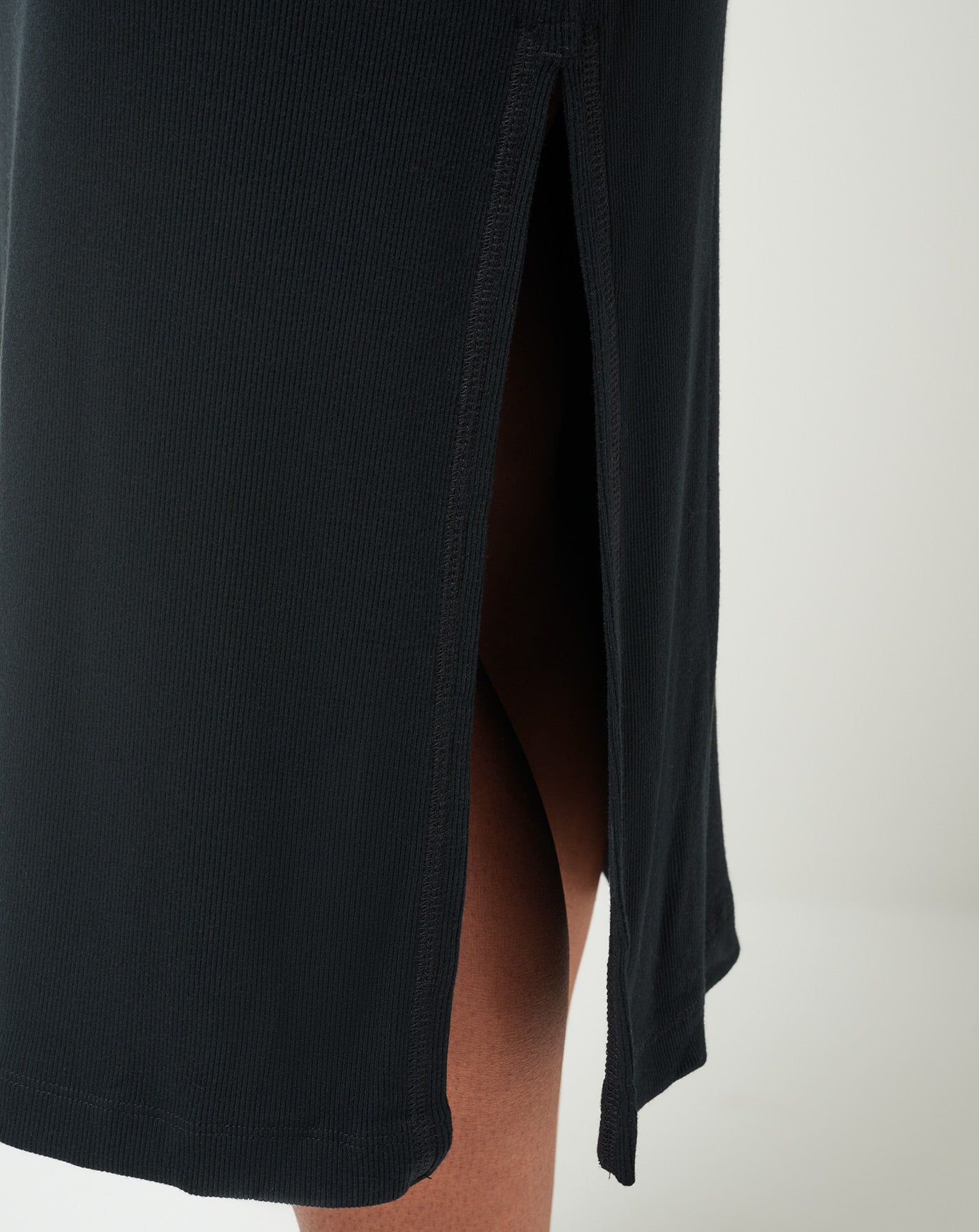 Black dress with a slit on a plain background