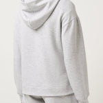 Person wearing a gray hoodie and shorts set on a white background