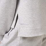 Close-up of a gray suit jacket with a brand logo on the chest pocket.