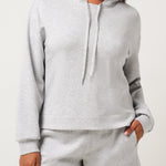 Woman wearing a gray hoodie and shorts set on a white background