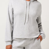 Woman wearing a gray hoodie and shorts set on a white background