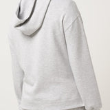Person wearing a gray hoodie and shorts set on a white background