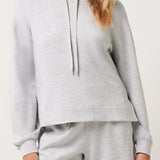 Woman wearing a gray hoodie and shorts set on a white background