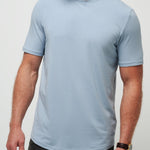 Man wearing a light blue t-shirt against a plain background