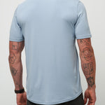 Man wearing a light blue t-shirt against a plain background