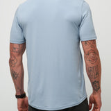 Man wearing a light blue t-shirt against a plain background