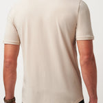 Man wearing a beige t-shirt on a plain background